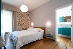 a bedroom with a bed and a stone wall at Agriturismo Fontanavecchia in Torrecuso