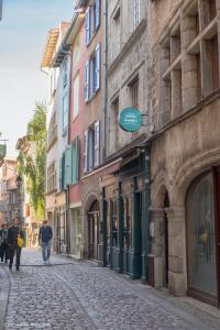 a cobblestone street with people walking down the street at La suite Capitaine Cook - Centre historique le Puy in Le Puy-en-Velay