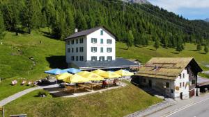an aerial view of a building with tables and umbrellas at Ristorante Albergo All'acqua in Bedretto