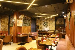 a restaurant with tables and chairs and a couch at Hotel Helios in Zirakpur