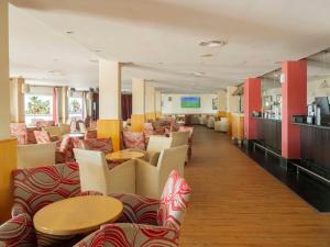 a restaurant with couches and tables and chairs at Ona Marinas de Nerja Spa Resort in Nerja