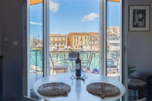 a table with a bottle of wine on top of a balcony at Le Petit Bijou Sète, 5 appartements in Sète