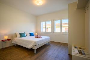 a white bedroom with a bed and a window at Residence Da Marco in Pieve di Soligo