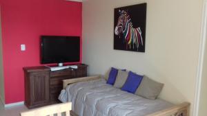 a living room with a couch and a flat screen tv at Departamento Temporario Villa Sol in Cordoba