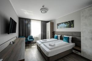 a bedroom with a large bed with blue pillows at Vital Hotel in Sofia