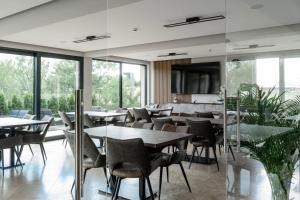 a restaurant with tables and chairs and large windows at Vital Hotel in Sofia