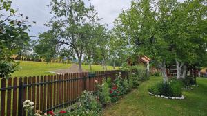 a fence with flowers and trees in a yard at Verina kuća in Kosjeric
