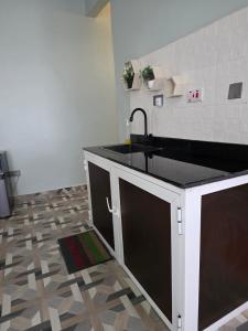 a kitchen with a sink and a tile floor at VC Heritage Residences in Dodoma