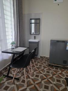 a dining room with a table and a tv at VC Heritage Residences in Dodoma