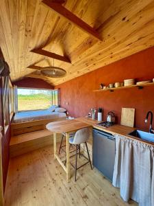 a kitchen with a wooden ceiling and a table at Tiny House en lisière de bois in Bastennes