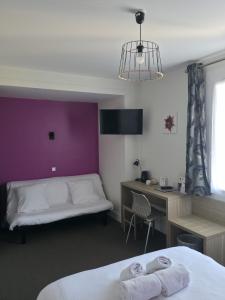 a room with a bed and a desk and a bed and a desk at The Originals City, Hôtel Le Savoy, Caen in Caen