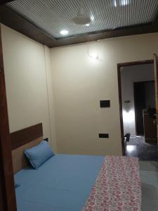 a bedroom with a bed with a blue pillow at Sarovar Home Stay in Vrindāvan