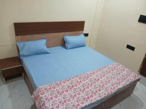 a bed with blue sheets and blue pillows at Sarovar Home Stay in Vrindāvan