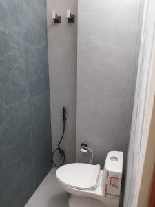 a bathroom with a toilet and a phone on the wall at Sarovar Home Stay in Vrindāvan