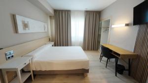 ein Hotelzimmer mit Bett und Schreibtisch in der Unterkunft Hotel Alaiz in Beriáin