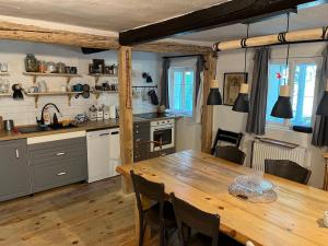 a kitchen and dining room with a wooden table at Chalupa Hubina in Snědovice