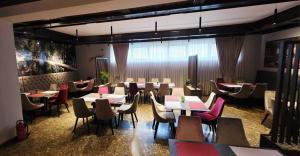 a restaurant with tables and chairs in a room at Picikato Rooms in Krapina