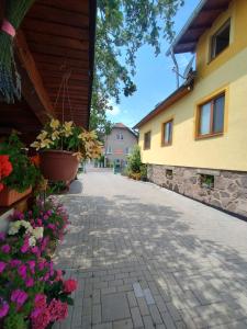 a walkway between two buildings with flowers at Apartmán Nebo in Turčianske Teplice