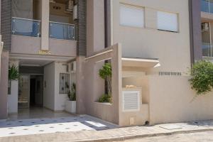 an apartment building with a entrance to a courtyard at Modern Hammamet Stay Pool & Beach in Hammamet Sud