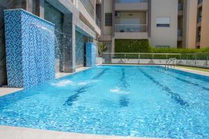 a swimming pool with a fountain in a building at Modern Hammamet Stay Pool & Beach in Hammamet Sud