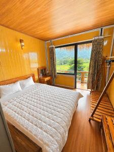 a bedroom with a bed and a large window at Green Homestay Mai Chau in Mai Châu +92 photos