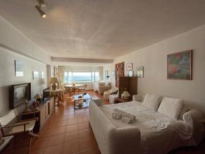 a living room with a white couch and a living room with a table at Costa 010 in Setúbal