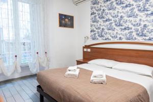 a bedroom with a large bed with two towels on it at Parri Silton in Rome