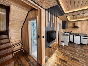 a kitchen with wooden walls and wooden floors at Uzungol Ada Bungalow in Uzungöl