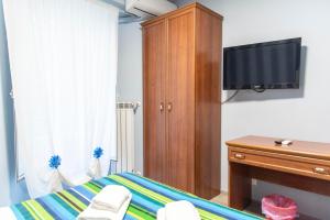 a bedroom with a tv and a wooden cabinet at Parri Silton in Rome