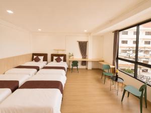 a row of beds in a room with a window at The 789 House in Chiang Mai