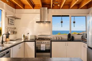a kitchen with a stove top oven next to a window at Ocean Views 20kms from CBD Sleeps 10 in Kingston Beach