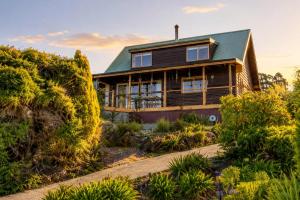 a wooden house with a green roof at Ocean Views 20kms from CBD Sleeps 10 in Kingston Beach