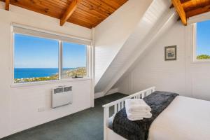 a bedroom with a bed and a large window at Ocean Views 20kms from CBD Sleeps 10 in Kingston Beach