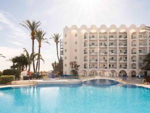 a hotel with a large swimming pool in front of a building at Ona Marinas de Nerja Spa Resort in Nerja