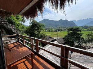 a wooden porch with a bench on a balcony with mountains at Green Homestay Mai Chau in Mai Châu