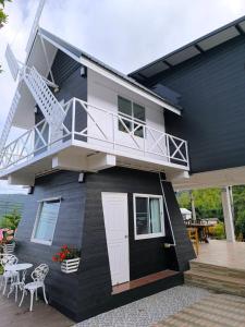 a house with a white door and a balcony at Ban Rai Rabeang Mok in Khao Kho