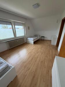an empty room with two beds and a wooden floor at Monterus Fürst in Fürstenau +1 photo