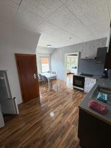 a kitchen with a wooden floor and a table in a room at Monterus Fürst in Fürstenau