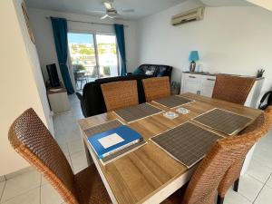 a dining room table with chairs and a laptop on it at Pegeia Sun in Peyia