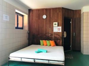 a bed in a small room with a clock on the wall at Hotel Selsky Dvur in Vyškov