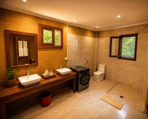a bathroom with two sinks and a toilet at Tiki Beach Economy in Paje +50 photos