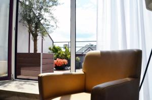 a brown chair sitting in front of a window at Tante ALMA Bristol Hotel in Frankfurt +24 photos