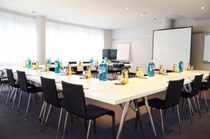 a conference room with a long table and chairs at Tante ALMA Bristol Hotel in Frankfurt