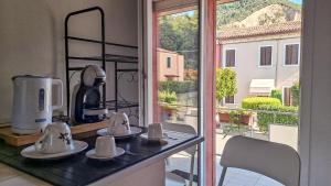 a kitchen with a counter with mugs and a window at Appartamenti Monte Selce in Monselice