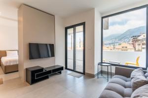 a living room with a couch and a flat screen tv at Les Jardins Kaslik in Al Bāţiyah