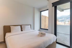a bedroom with a bed and a large window at Les Jardins Kaslik in Al Bāţiyah