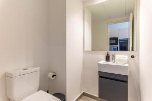 a white bathroom with a toilet and a sink at Les Jardins Kaslik in Al Bāţiyah +46 photos