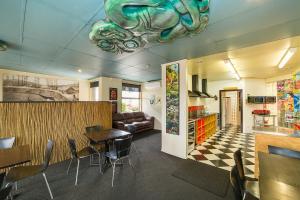 
a kitchen filled with furniture and a refrigerator at Tahuna Pod Hostel in Queenstown
