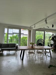 a living room with a large wooden table and chairs at The Garden room in Ikšķile
