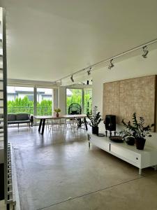 a large living room with tables and plants in it at The Garden room in Ikšķile